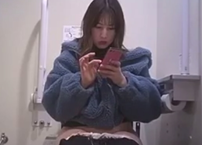 用を足しながらスマホを弄るお姉さんのトイレ盗撮動画！